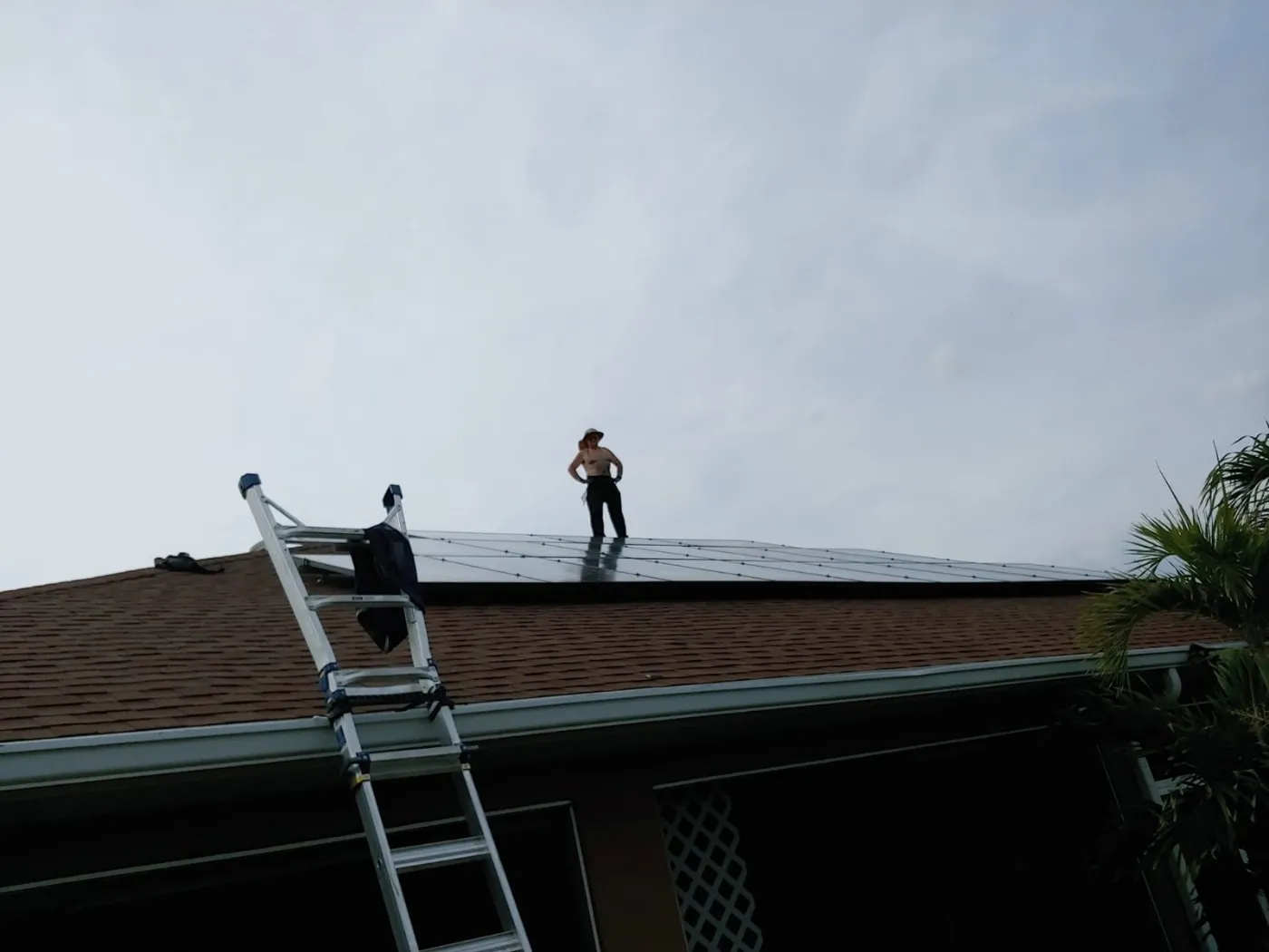 Art of Solar crew on a roof with a ladder during a solar reinstall