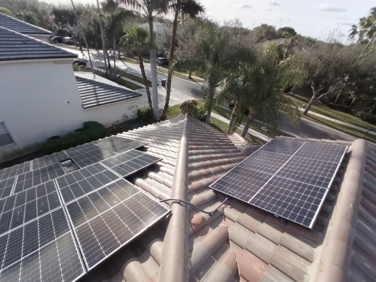 Solar panels along a roof ridge with a view of the neighborhood